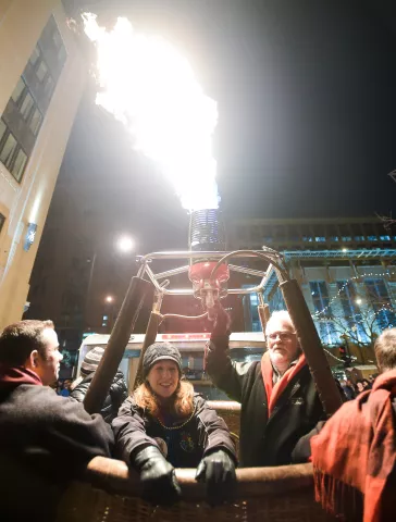 Jen Tamburo of Afton hangs on for the ride inside a hot air balloon basket at the Winter Carnival Torchlight Parade on Feb. 6, 2016. (Special to the Pioneer Press: Craig Lassig)