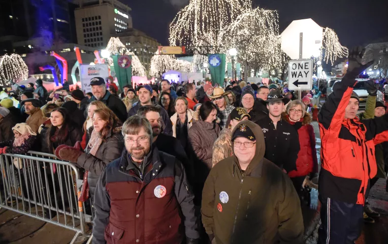 With Rice Park as a festive backdrop, Guy Palmateer of New Brighton, bottom left, and Brian Rydzeski of Shoreview watch the Torchlight Parade on Fifth Street in downtown St. Paul on Saturday, Feb. 6, 2016. (Special to the Pioneer Press: Craig Lassig)