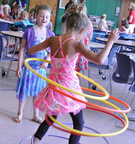 Lydia Schultz, 6, watches with delight as 7-year-old Brielle Bitzan hula hoops at Watercade's Prince and Princess for a Day.