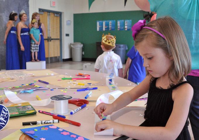 Elly Woelfel, 5, decorates a princess sash while Gavin Terning, 6, poses in the background with princess Kate Carlson, Miss Litchfield Kristen Klaben and princess Paige Dilley.