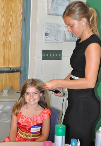 Sloan Quinn, 7, smiled as newly crowned Miss Litchfield Maddy Larson curled her hair during “Prince &amp; Princess For a Day” at Litchfield High School.