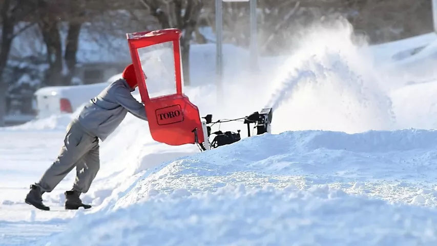 Aaron Braun puts in extra effort to get through the pile of snow at the end of his Mankato, Minn., driveway Monday, Jan. 28, 2019. (Pat Christman/The Free Press via AP)