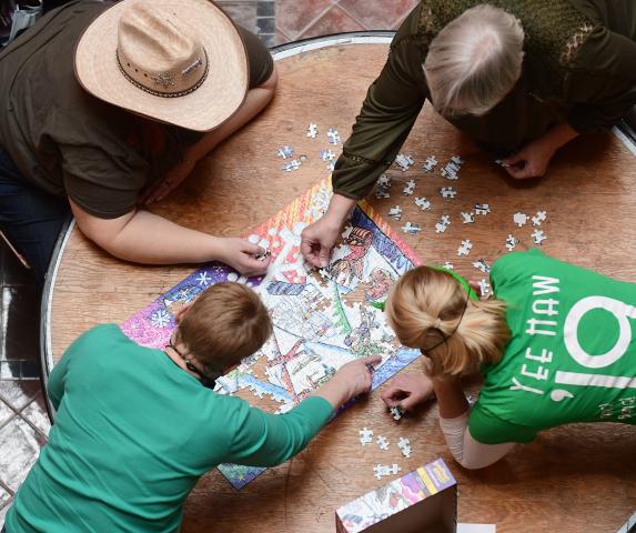 Frankie Benson, top right, her mom Suzanne Benson, top left, Kara Martin, bottom right, and her mom Nancy Berzelius, bottom, work on their puzzle in the Adult 1 category of the St. Paul Winter Carnival Puzzle Contest at the Landmark Center in downtown St. Paul on Saturday, Jan., 30, 2021. Sponsored by PuzzleTwist® roughly 150 teams in four categories competed to complete puzzles in the fastest time. (John Autey / Pioneer Press)