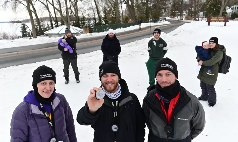 With the rest of their team behind them, St. Paul Pioneer Press Treasure Hunt Medallion finders (l-r) Julie Schonhardt, Josh Ellingson and Zak Rexford pose with their find at West Park in White Bear Lake on Sunday, Jan. 31, 2021. It was the second year that the team found the medallion. (John Autey / Pioneer Press)