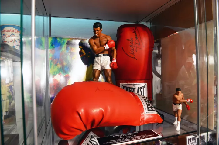 A glass case containing Muhammed Ali memorabilia -- including boxing gloves signed by Ali and by his trainer Angelo Dundee --is among the memorabilia in the collection of Tom Barrett, seen in the basement of his home on Wednesday, Jan. 12, 2022. (Scott Takushi / Pioneer Press)